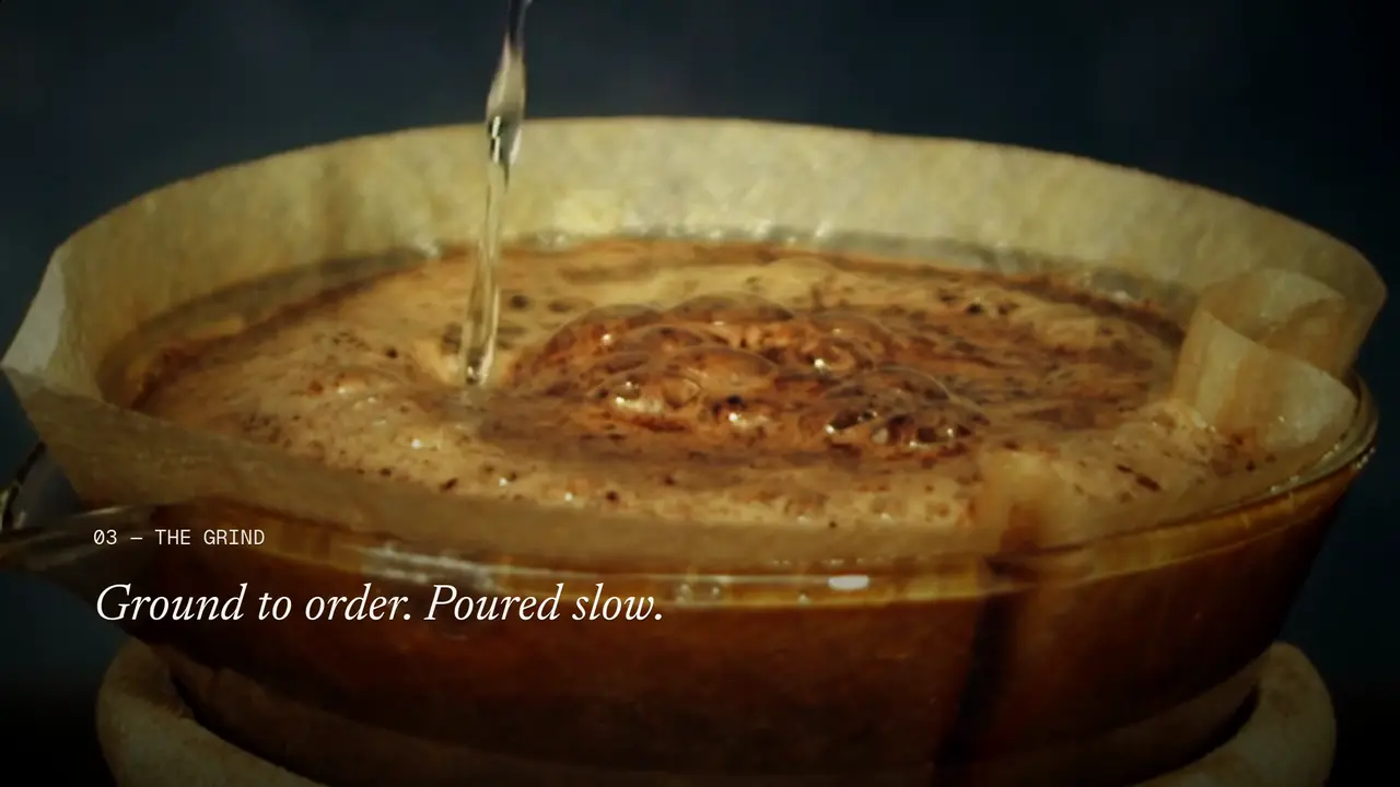 A frame from the final cut of the Northfold showcase edit: water poured over freshly ground coffee, with the title “Ground to order. Poured slow.”