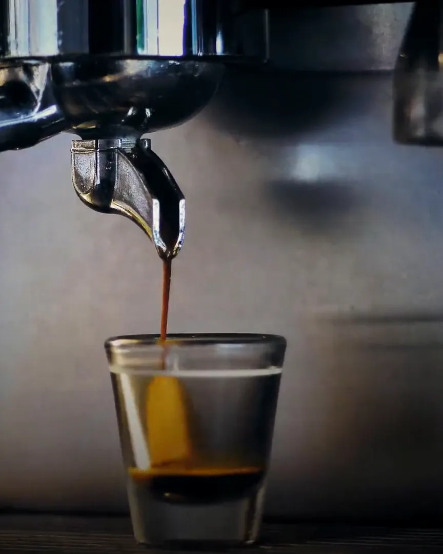 An espresso shot pouring into a small glass